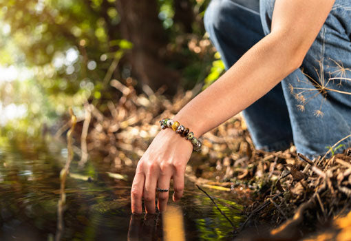 Model hiking by lake in forest with nature inspired jewellery