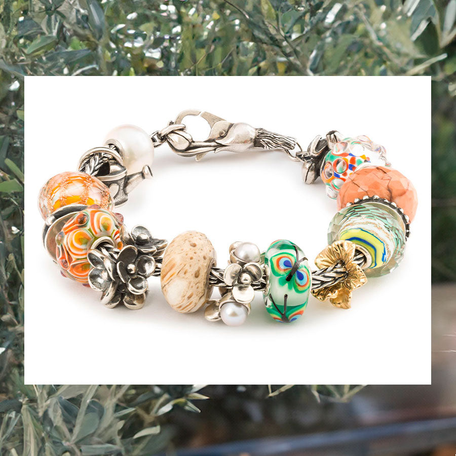 Trollbeads Foxtail bracelet with beads connectors and a lock from the nurtured connections collection on a background with olive trees